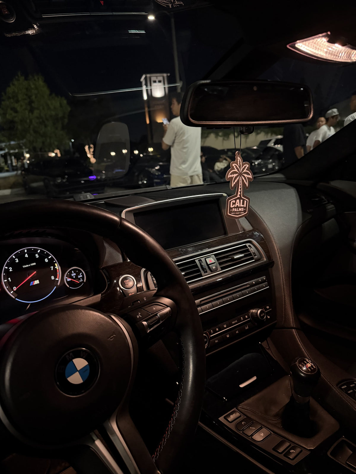 Cali Palms air freshener inside a BMW at a nighttime car meet