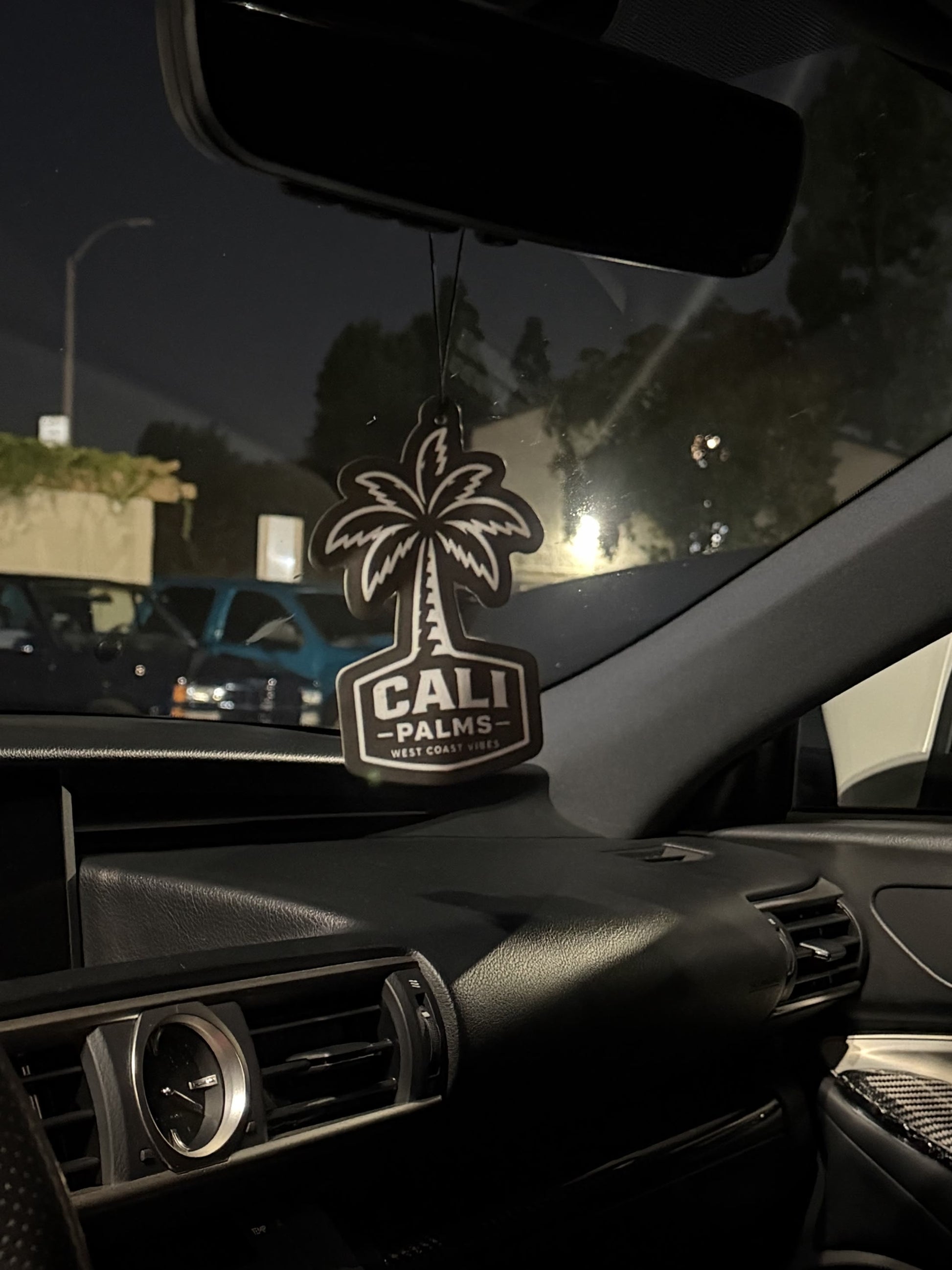 Cali Palms Palm Tree car air freshener hanging above a vehicle dashboard