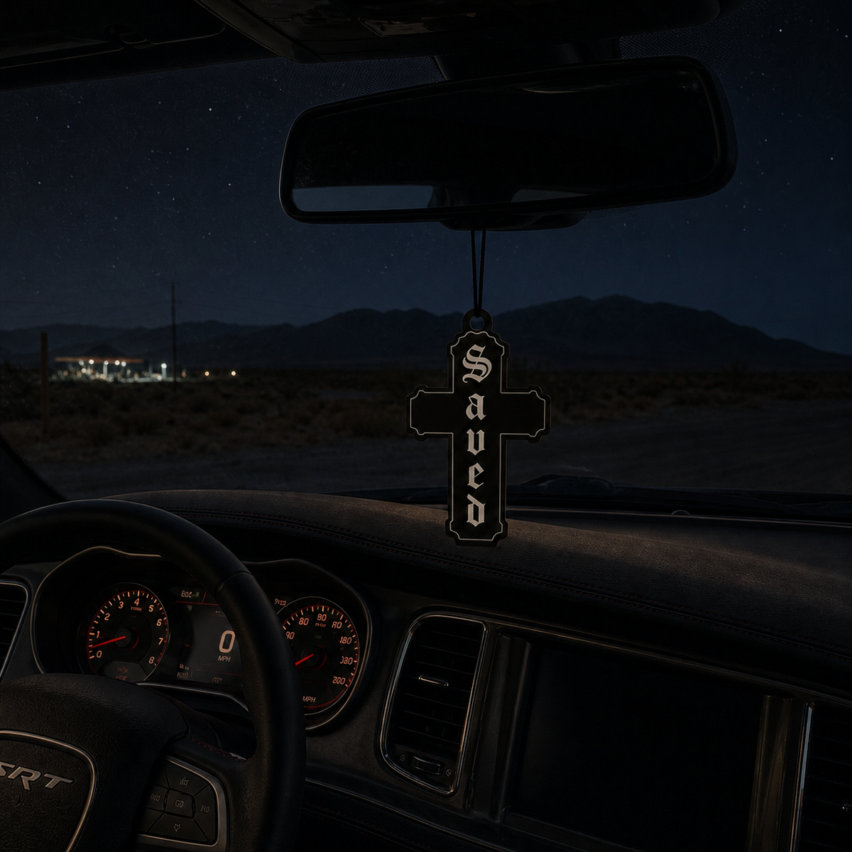 Saved Cross car air freshener in a nighttime car interior