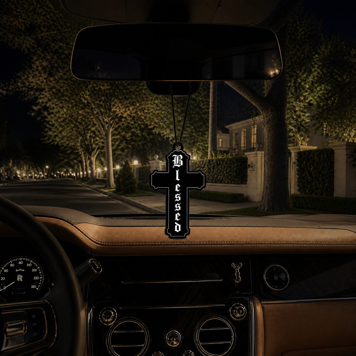 Blessed Cross car air freshener in a nighttime car interior